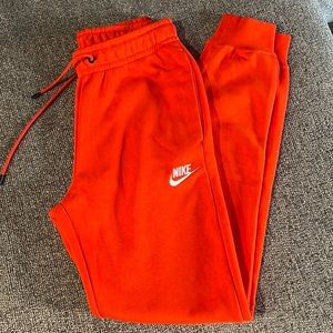 NWOT Orange Nike mid-rise joggers.